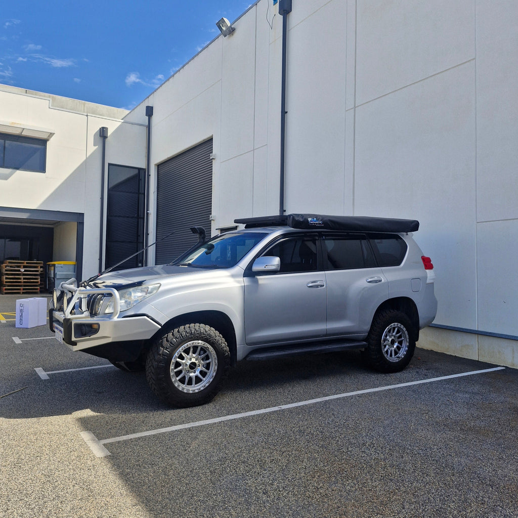 Silver SUV parked on a street with a building in the background