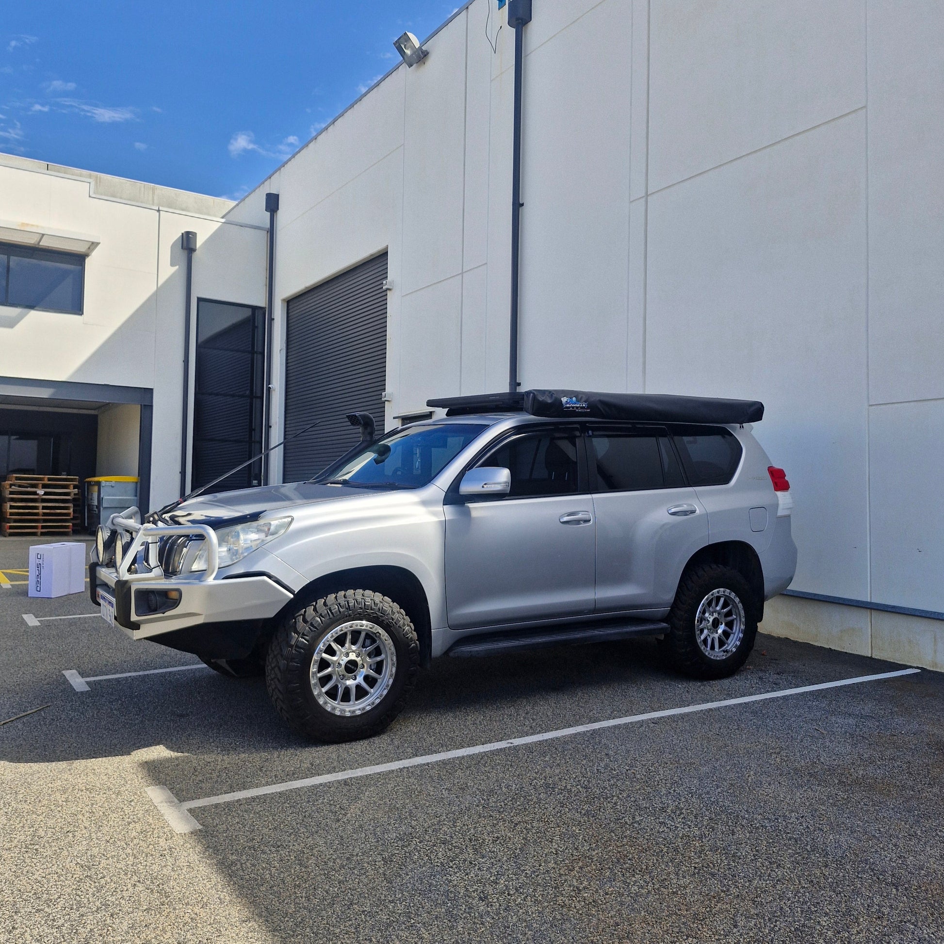 Silver SUV parked on a street with a building in the background
