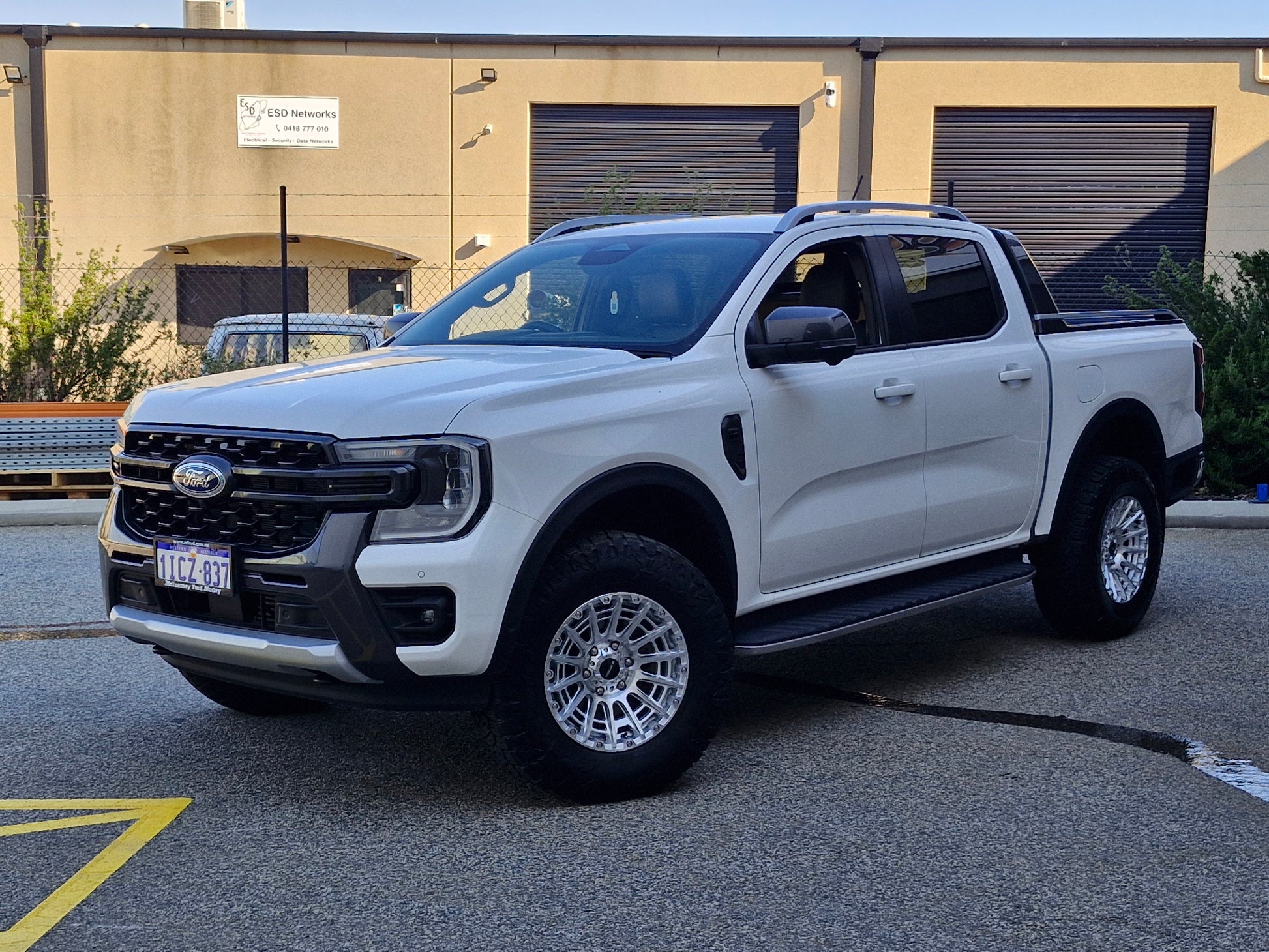 Car parked on a street with a clear blue sky ford ranger wildtrack next gen dspeed 4x4 wheels xt3 xt-3
