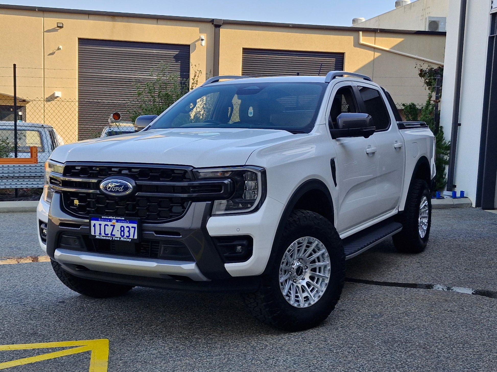 Car parked on a street with a clear blue sky ford ranger wildtrack next gen dspeed 4x4 wheels xt3 xt-3