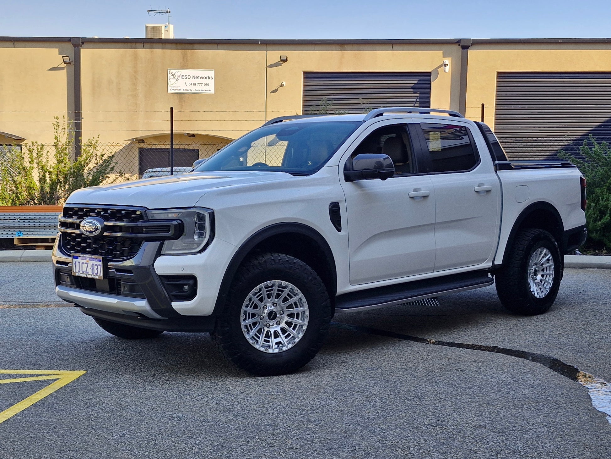 Car parked on a street with a clear blue sky ford ranger wildtrack next gen dspeed 4x4 wheels xt3 xt-3