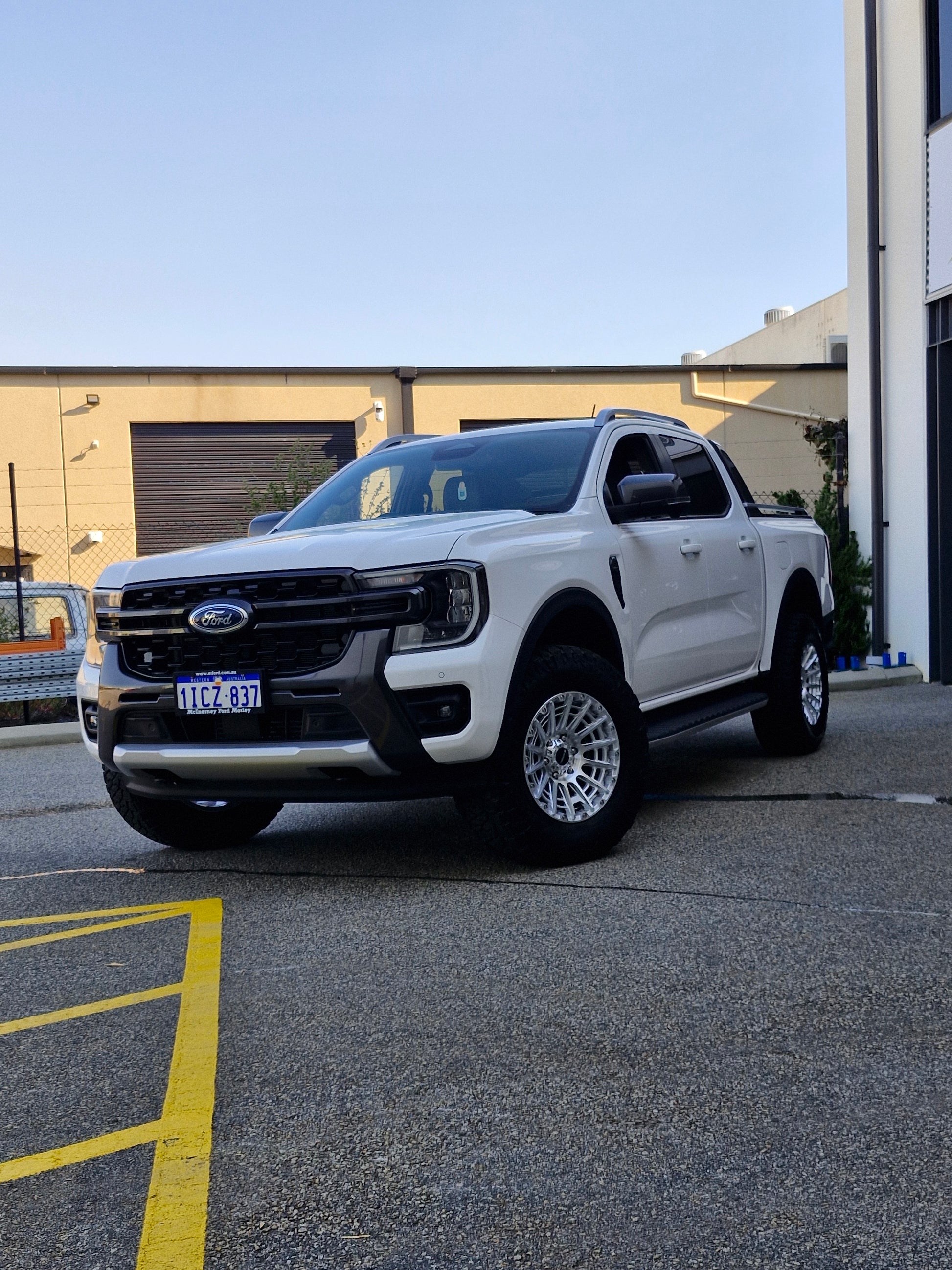 Car parked on a street with a clear blue sky ford ranger wildtrack next gen dspeed 4x4 wheels xt3 xt-3