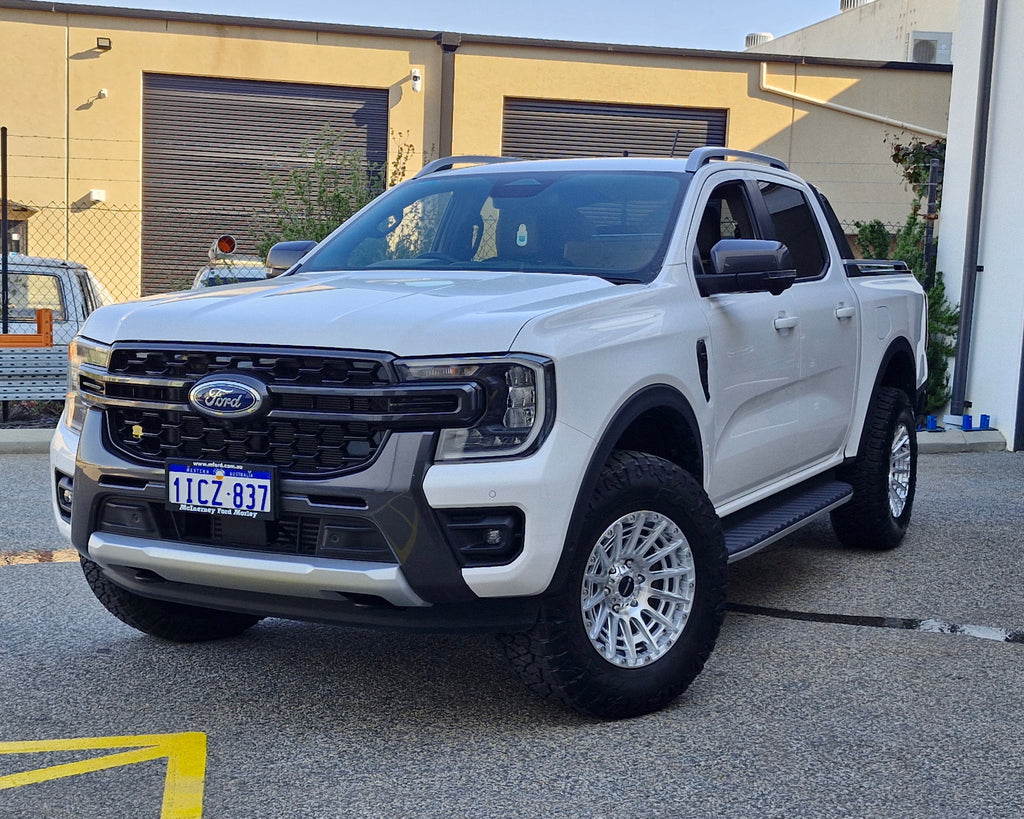 White Ford pickup truck parked in a lot with 4x4 wheels machined silver 17x8.5 500kg load rating high load rating gvm