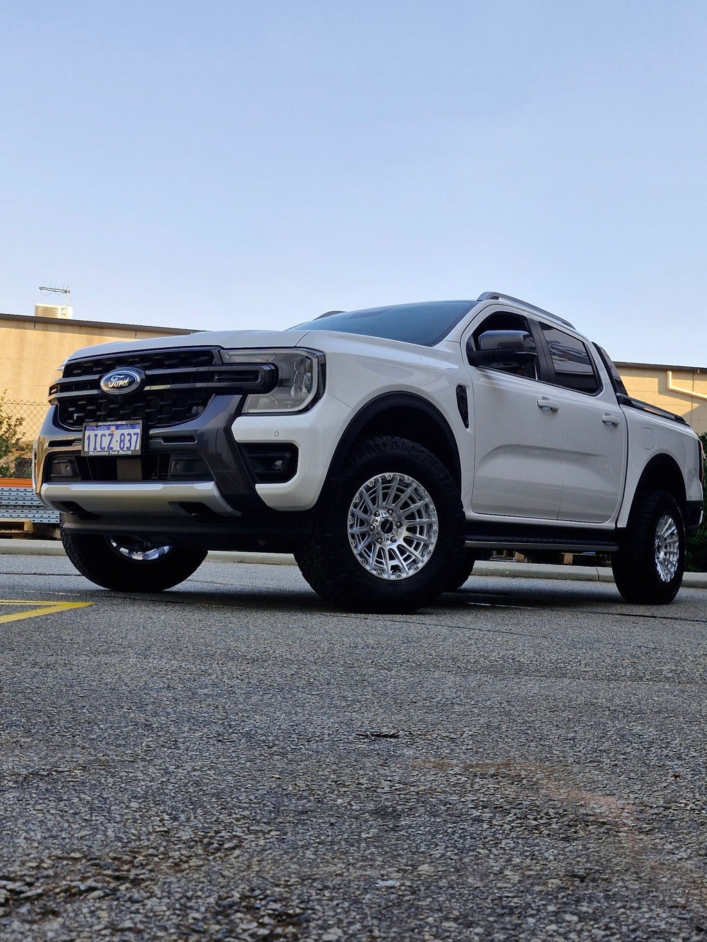 White Ford pickup truck parked in a lot with 4x4 wheels machined silver 17x8.5 500kg load rating high load rating gvm