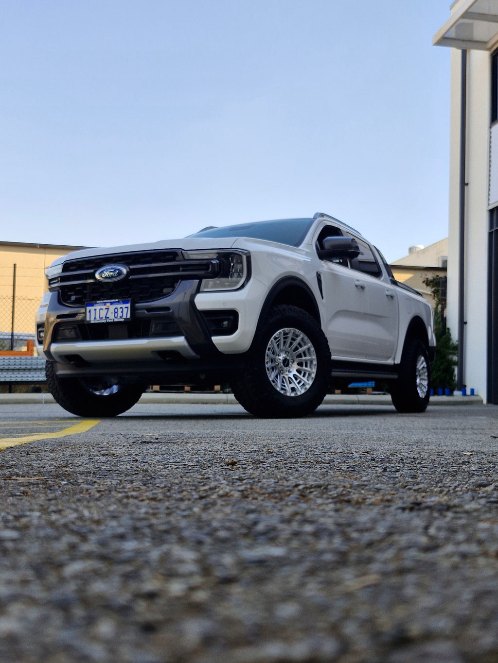 White Ford pickup truck parked in a lot with 4x4 wheels machined silver 17x8.5 500kg load rating high load rating gvm