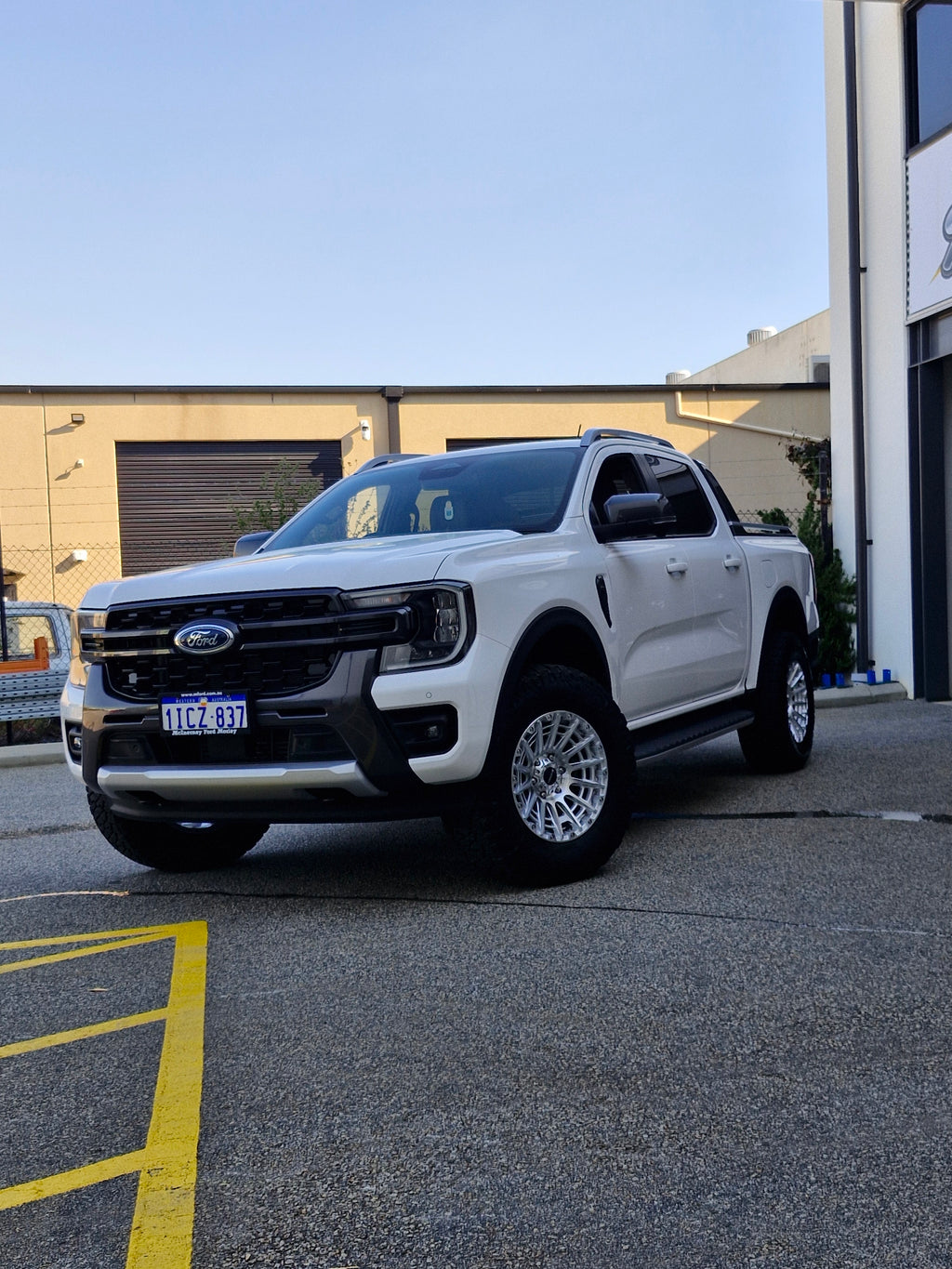White Ford pickup truck parked in a lot with 4x4 wheels machined silver 17x8.5 500kg load rating high load rating gvm