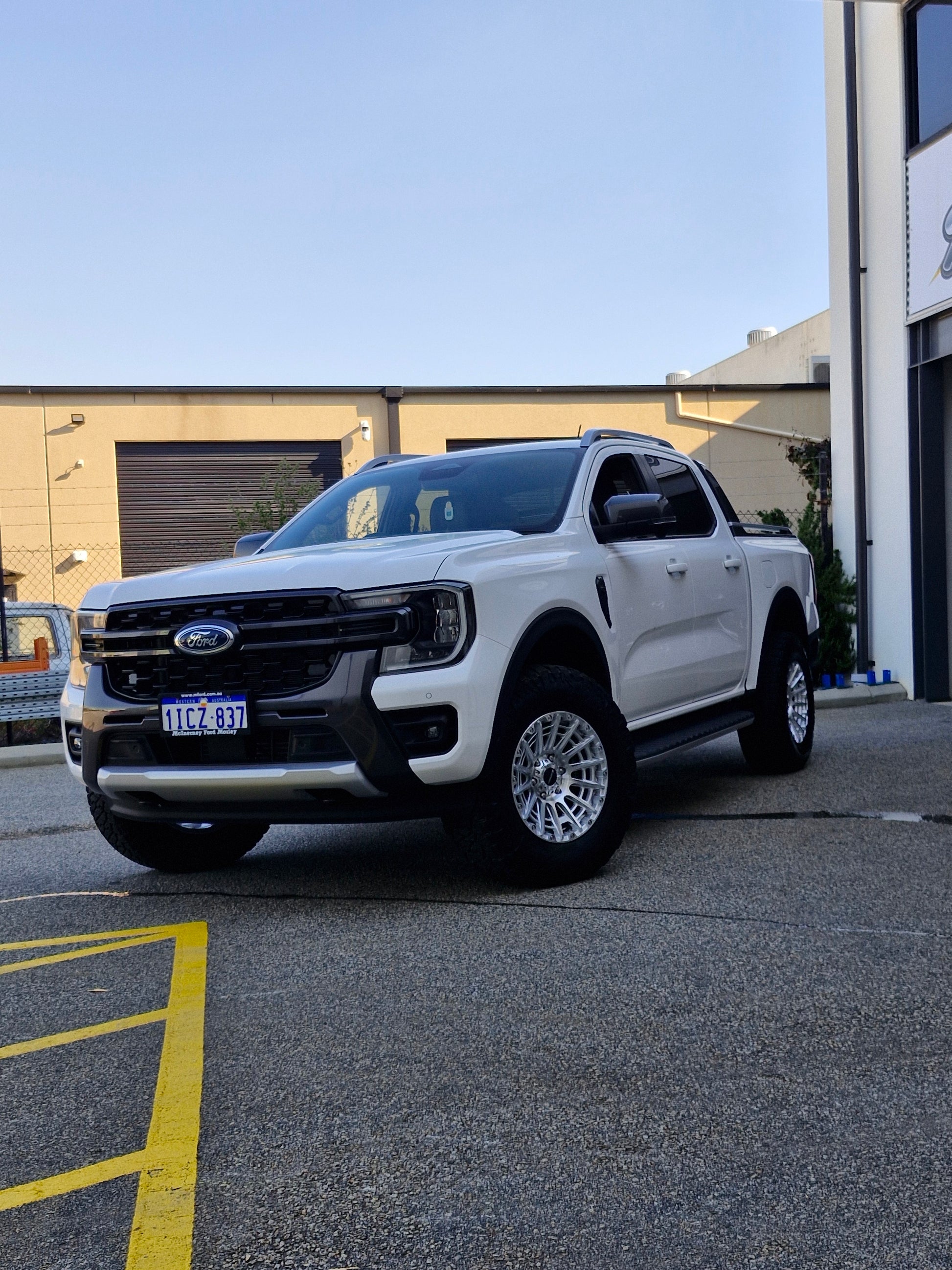 White Ford pickup truck parked in a lot with 4x4 wheels machined silver 17x8.5 500kg load rating high load rating gvm