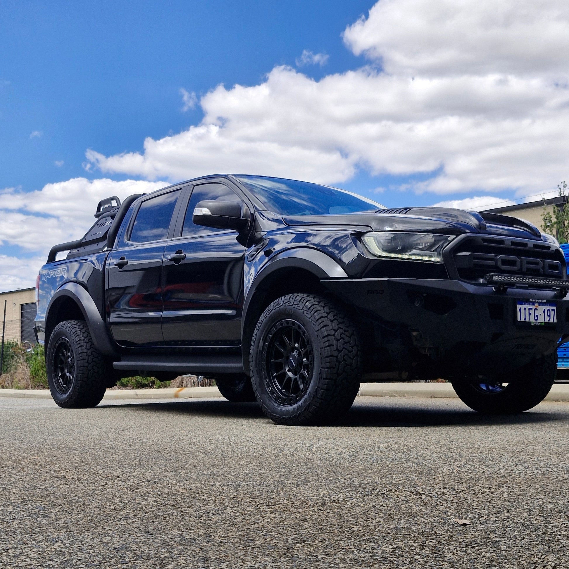 Black FORD RANGER RAPTOR parked on a street with a building in the background DSPEED XT1 XT-1 4X4 WHEELS