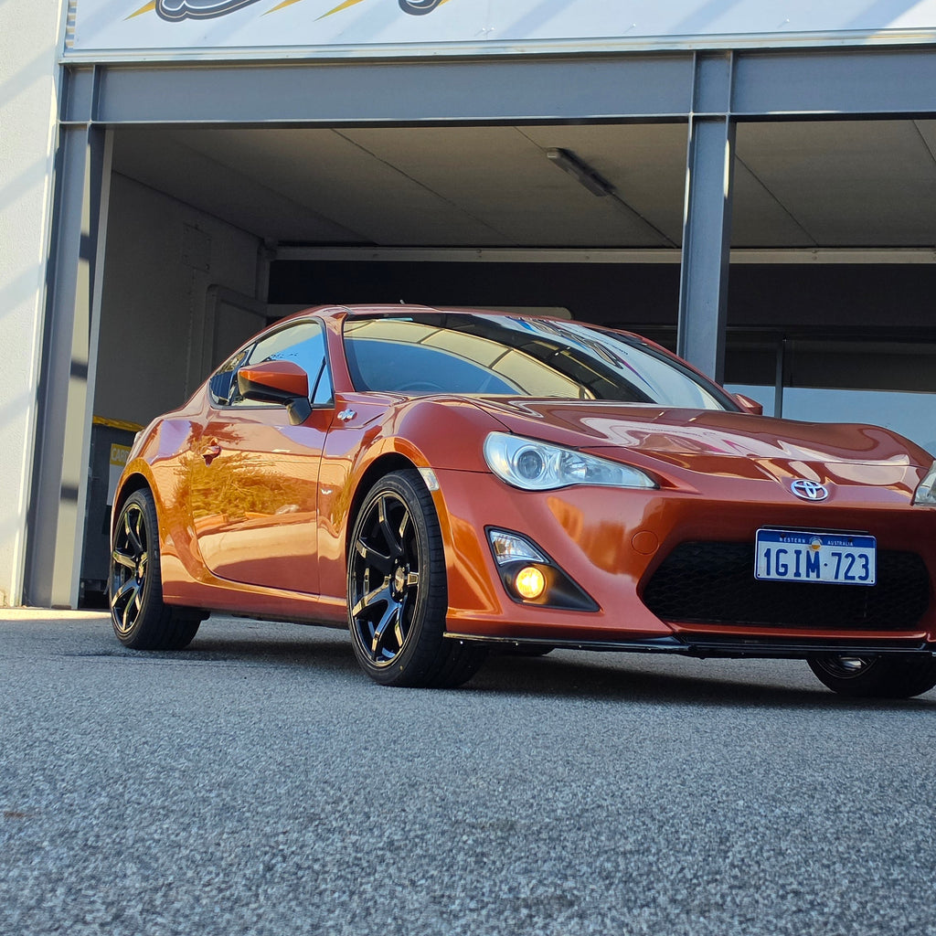A metallic copper orange sports car parked inside a garage bay, with a large vertical banner reading 'd Speed ' hanging beside the open DSpeed DS-07 ds07 18x8.5 +35 5x100 alloy wheels rims concave gloss black