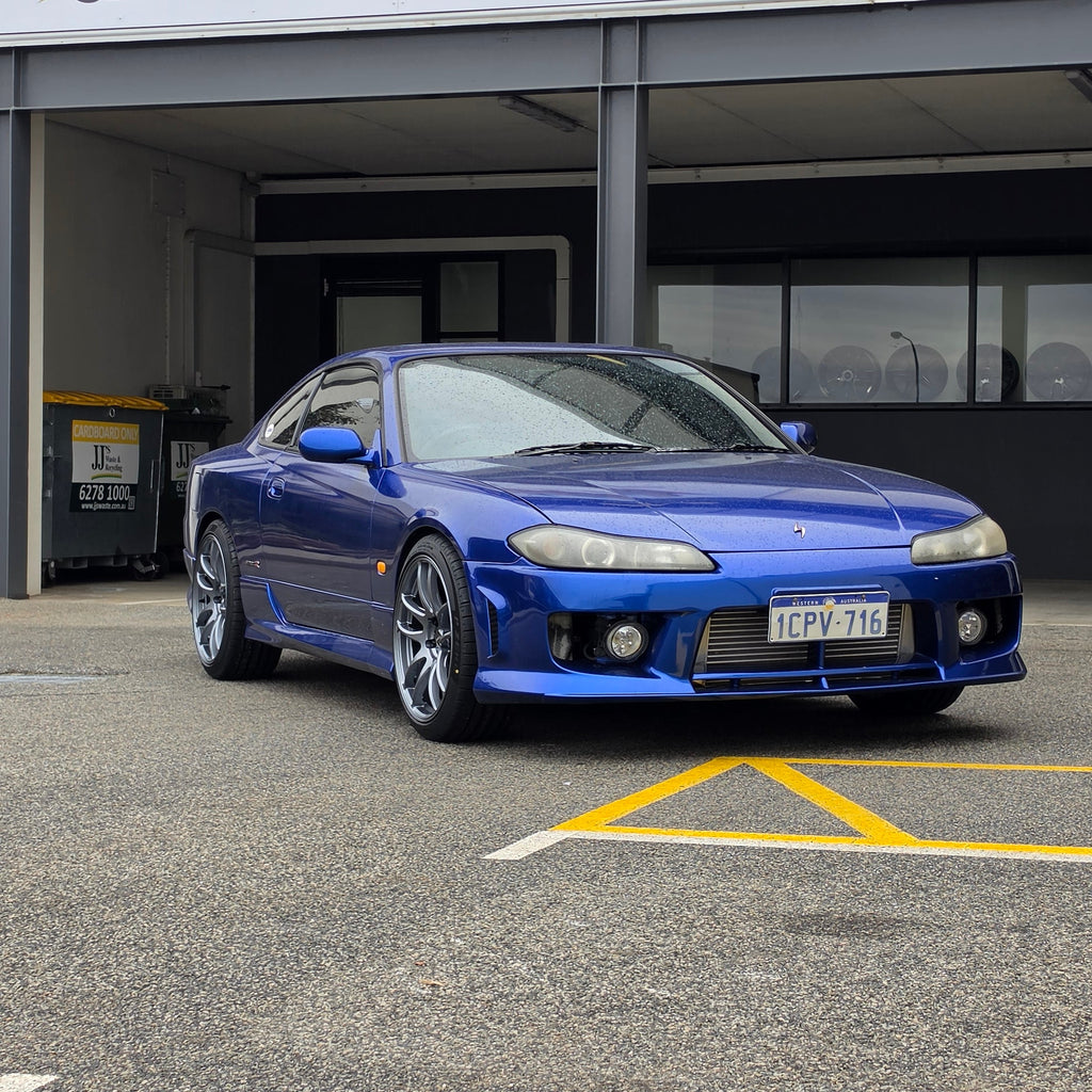 A blue Nissan 200sx s15 s13 s14 sports car parked on an asphalt DSpeed performance wheels D-Speed ds02 ds-02 wheels 18x8.5 +25 5x114.3 Gunmetal rims tyres wheel and tyre package