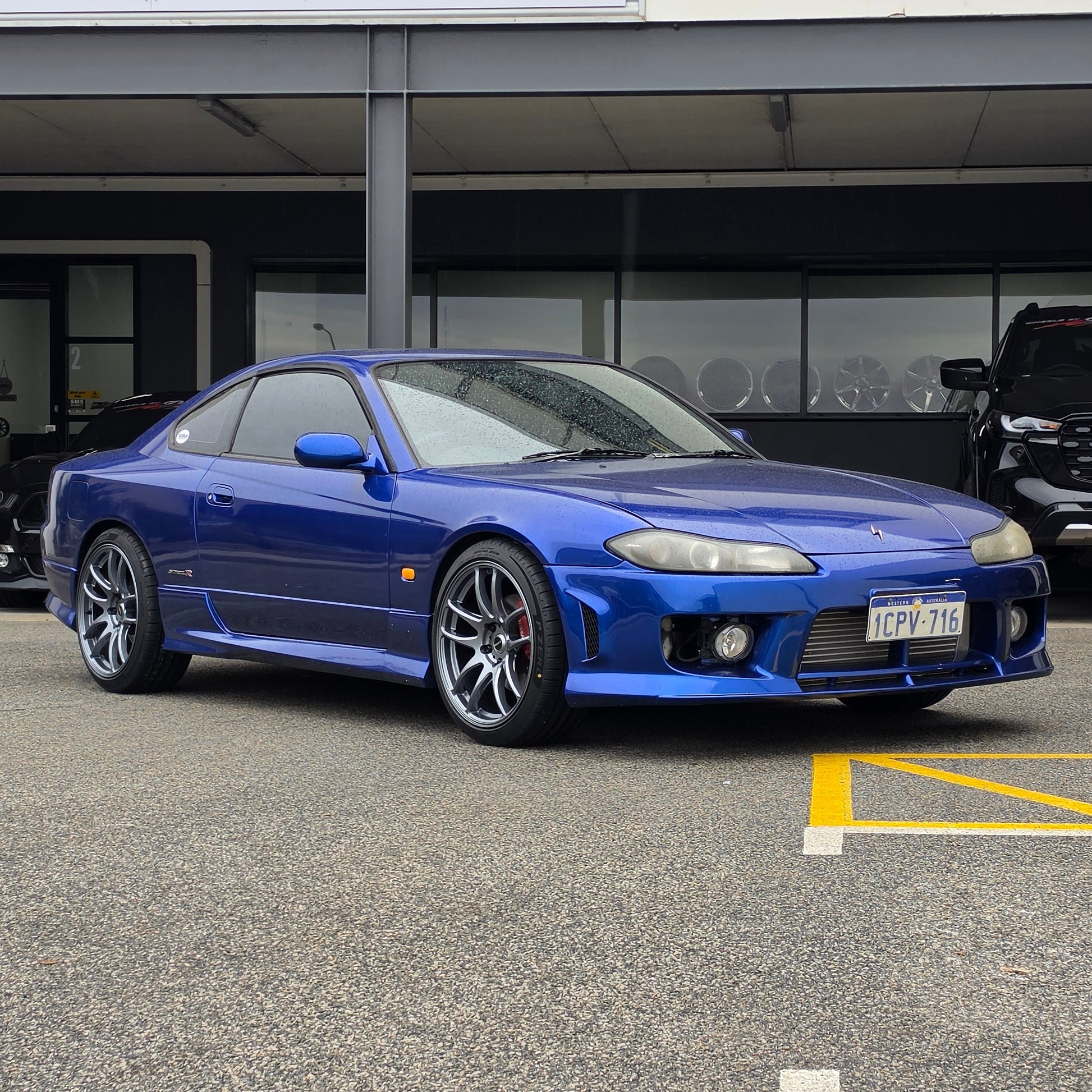 A blue Nissan 200sx s15 s13 s14 sports car parked on an asphalt DSpeed performance wheels D-Speed ds02 ds-02 wheels 18x8.5 +25 5x114.3 Gunmetal rims tyres wheel and tyre package