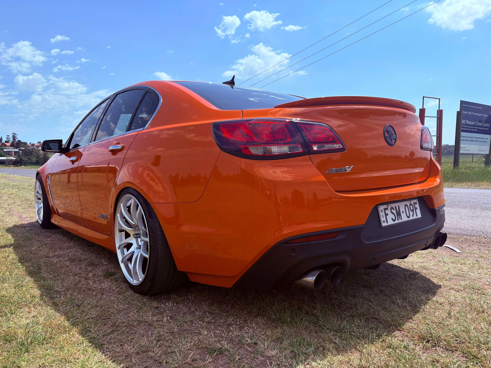 Orange car parked on grass with a clear blue sky dspeed ds02 19x9.5 wheels