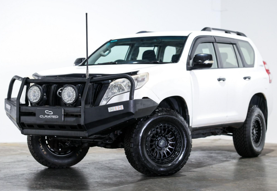 A white Toyota Land Cruiser PRADO SUV with a black front bumper guard, auxiliary lights, and off-road tires, photographed in a studio setting. 4X4 WHEELS DSPEED OFFROAD Off road MH-2 mh2 17x8.5 17inch 4x4 wheels rims deep dish black satin black