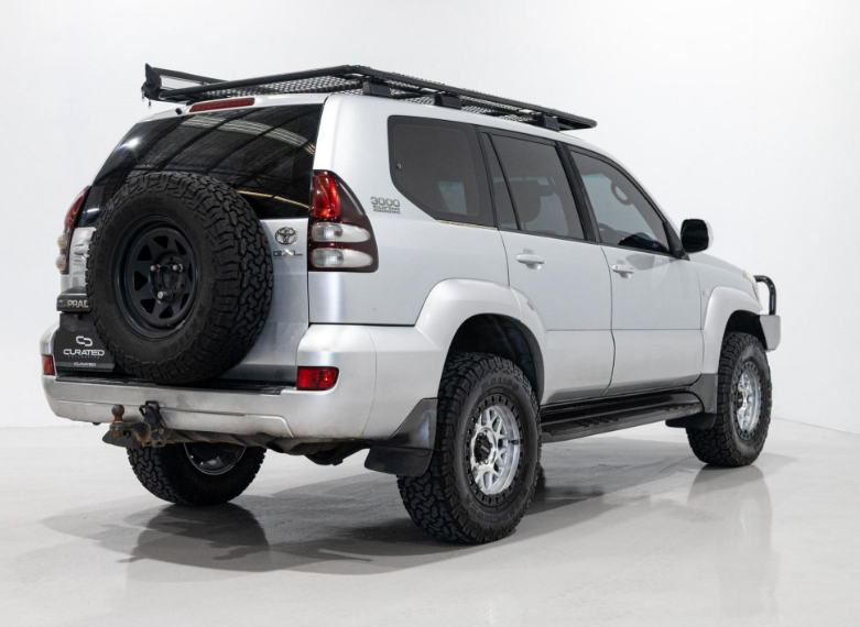 A white Toyota Land Cruiser PRADO SUV with a black front bull bar, black roof rack, and D-Speed MH-1 dspeed mh1 machined silver with black ring wheels rims alloys 17x8.5 17x9 with 275/70R17 Roadcruza RA1100 all terrain tyres off road offroad 4x4