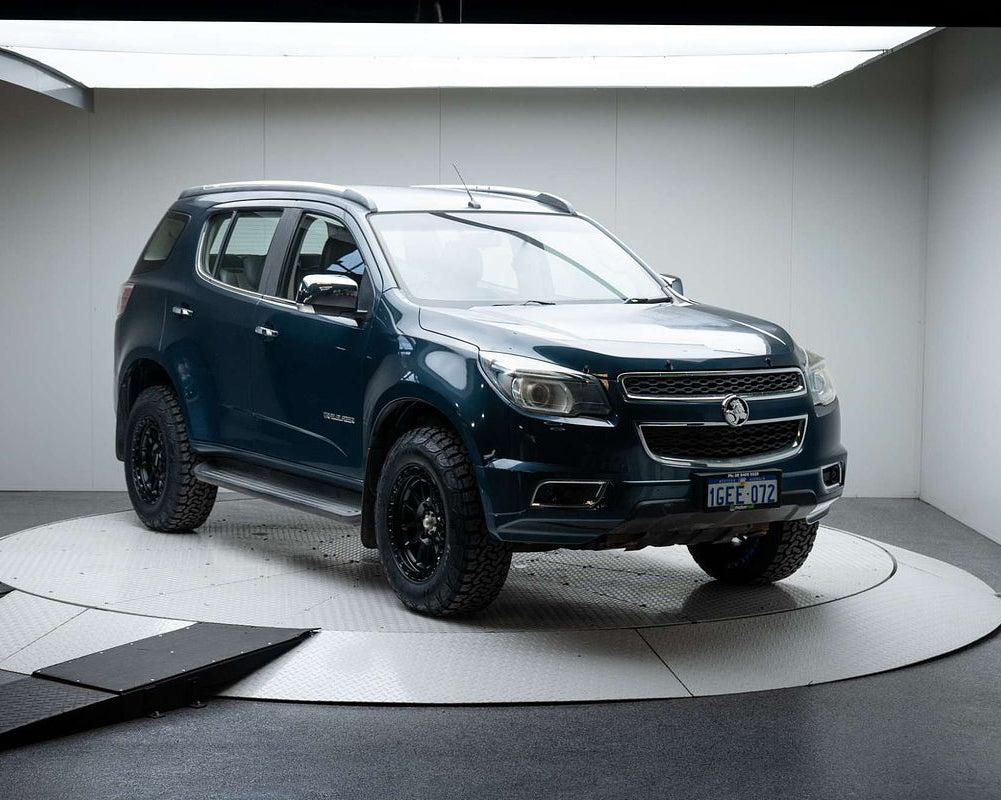 A dark metallic blue-gray Chevrolet Colorado pickup truck with off-road tires and black wheels, displayed on a circular white platform inside a studio setting. dspeed xt1 D-Speed XT-1 wheel with AT all terrain tyres 4x4 wheels rims off road offroad