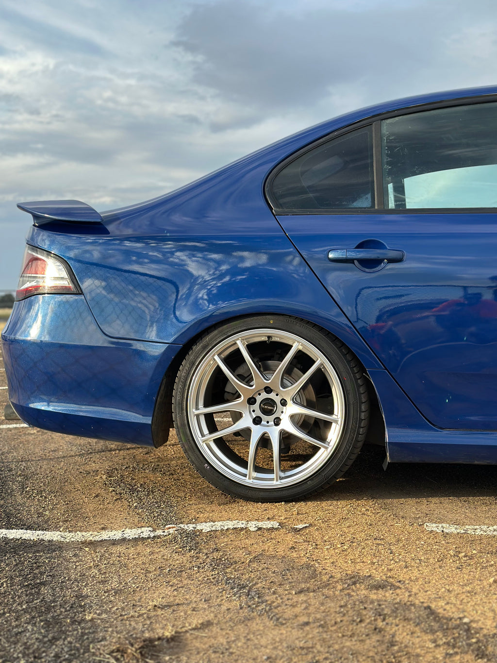 Blue car parked on a city street at night with buildings and lights in the background. Ford FG Falcon dspeed D-Speed DS02 DS-02 wheels 19x8.5 tyre package