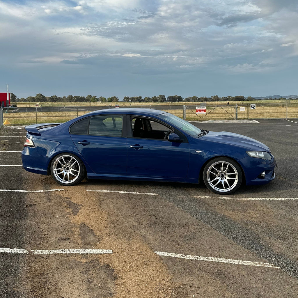 Blue car parked on a city street at night with buildings and lights in the background. Ford FG Falcon dspeed D-Speed DS02 DS-02 wheels 19x8.5 tyre package