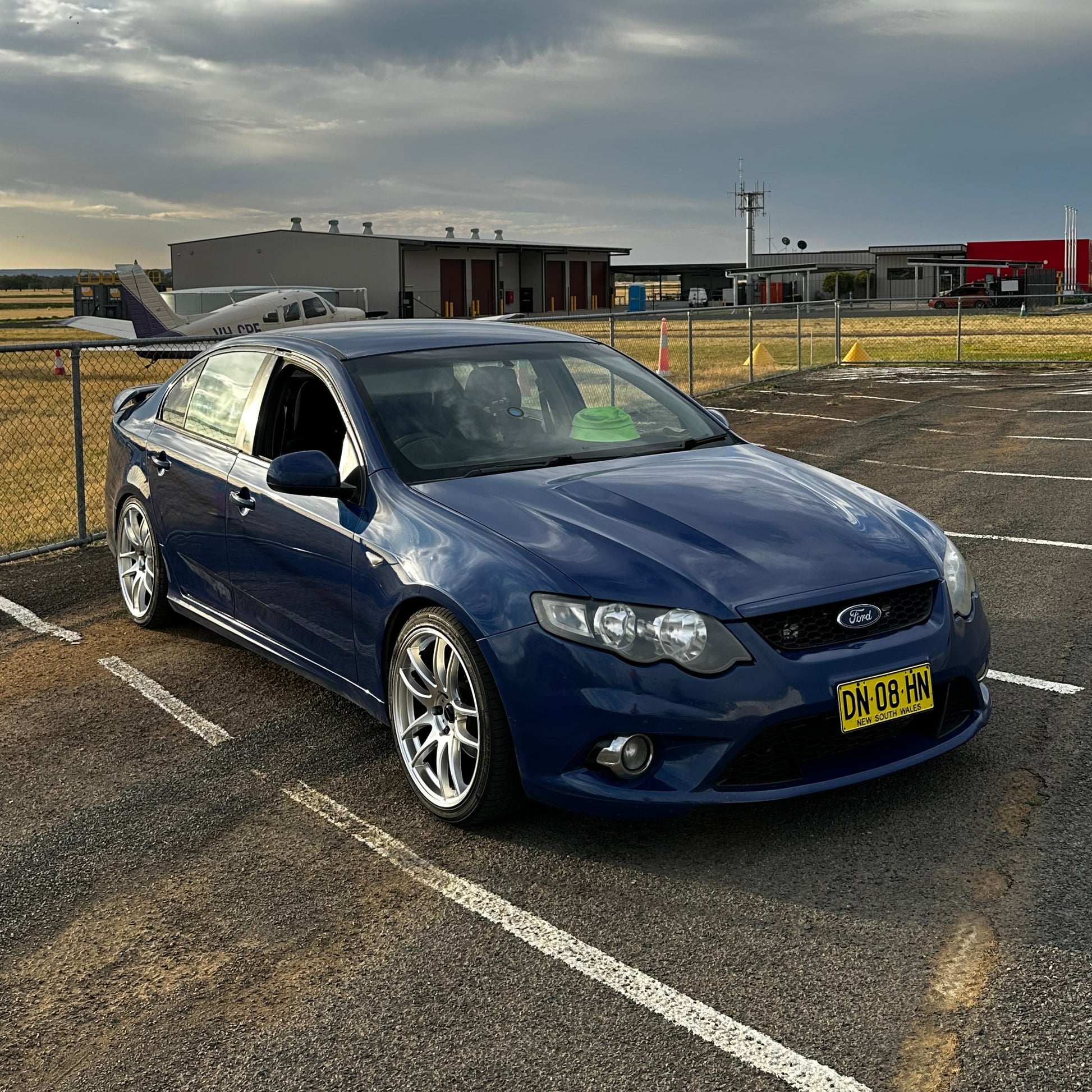 Blue car parked on a city street at night with buildings and lights in the background. Ford FG Falcon dspeed D-Speed DS02 DS-02 wheels 19x8.5 tyre package