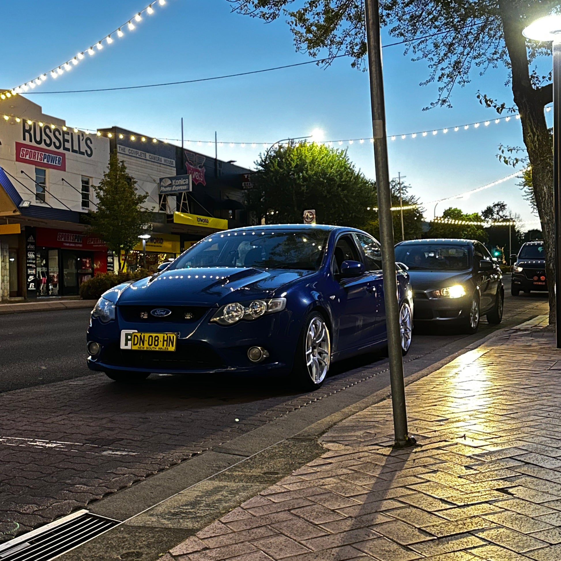 Blue car parked on a city street at night with buildings and lights in the background. Ford FG Falcon dspeed D-Speed DS02 DS-02 wheels 19x8.5 tyre package
