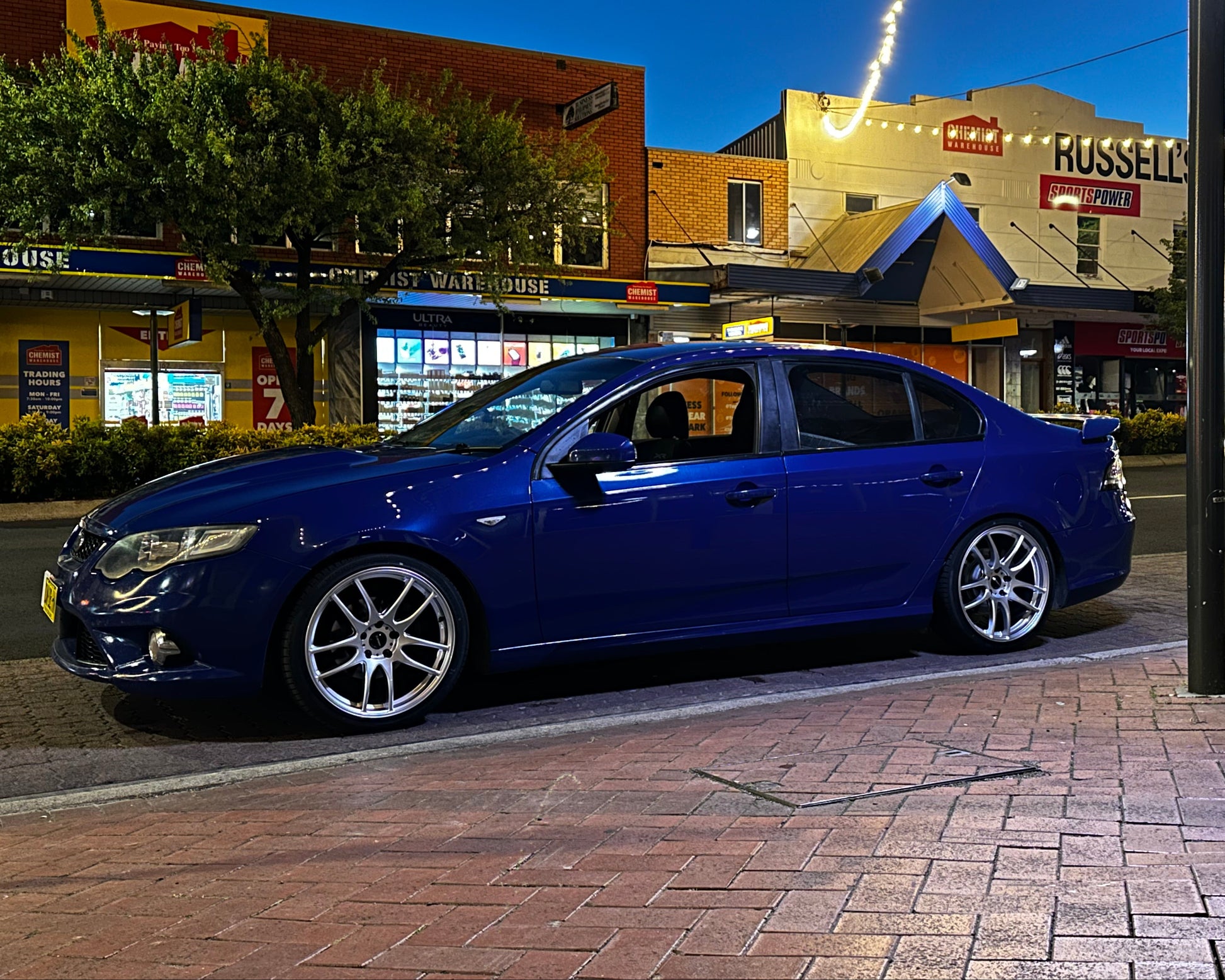 Blue car parked on a city street at night with buildings and lights in the background. Ford FG Falcon dspeed D-Speed DS02 DS-02 wheels 19x8.5 tyre package