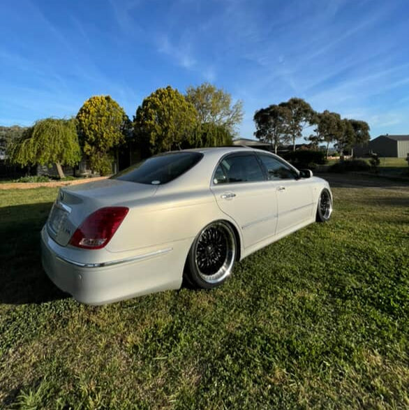 Silver car parked on grass with a clear blue sky toyota crown with 19x9.5 wheels Dspeed performance wheels