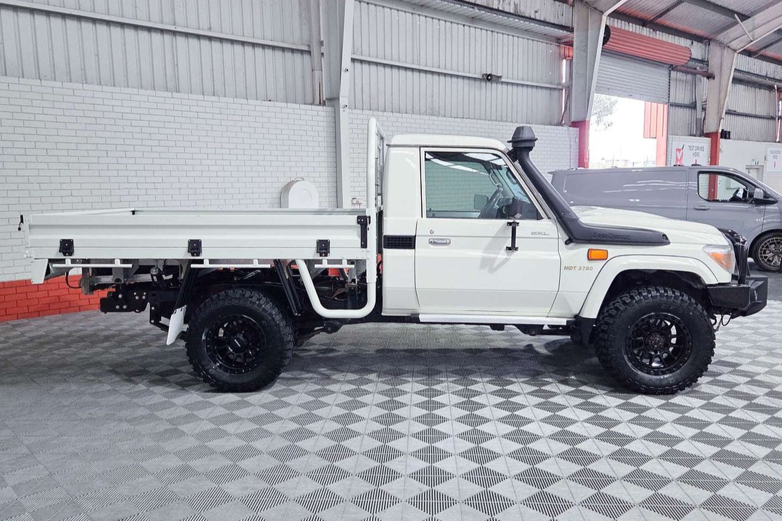White pickup truck with a flatbed in a garage setting toyota landcruiser 79 series dspeed xt1 wheels