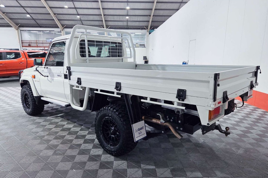 White pickup truck with a flatbed in a garage setting toyota landcruiser 79 series dspeed xt1 wheels